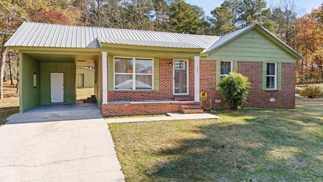 view of front facade with concrete driveway, metal roof, a front lawn, brick siding, and a carport
