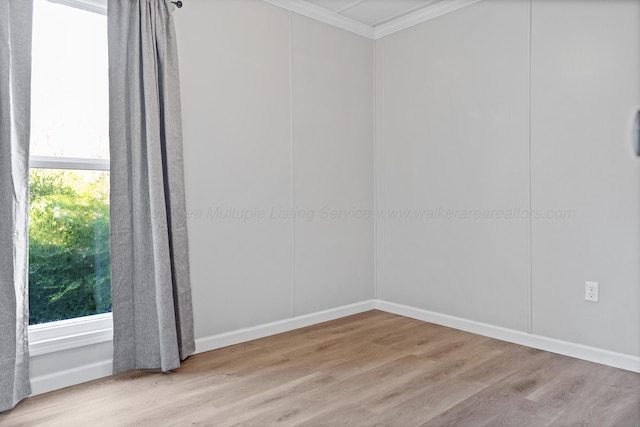 spare room with wood finished floors and ornamental molding