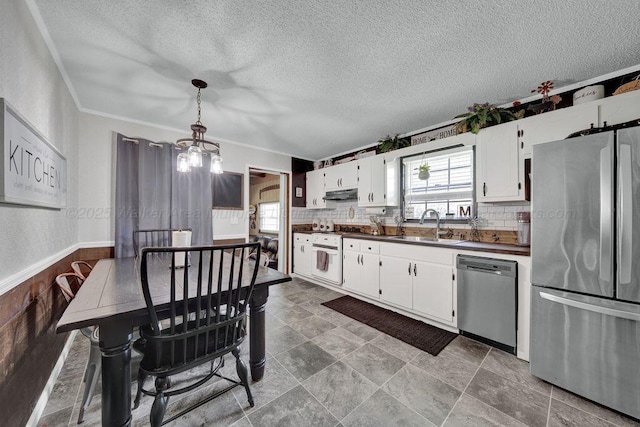 805 3rd Ave, Jasper, AL 35501 - kitchen with stainless steel appliances, under cabinet range hood, white cabinetry, a chandelier, and dark countertops