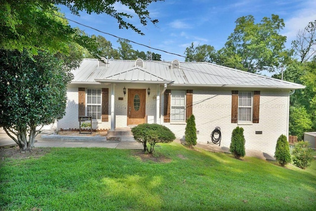 805 3rd Ave, Jasper, AL 35501 - view of front of house featuring brick siding, a front lawn, and a metal roof