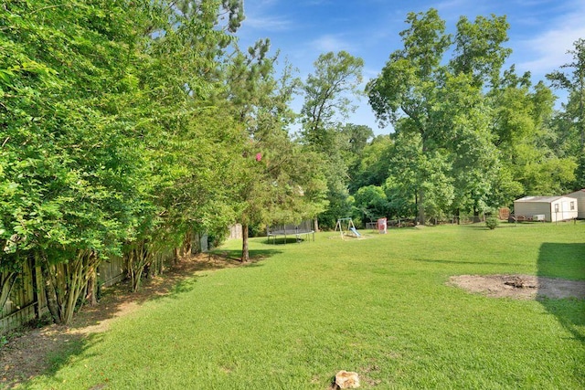 805 3rd Ave, Jasper, AL 35501 - view of yard featuring a trampoline, a playground, and a storage shed