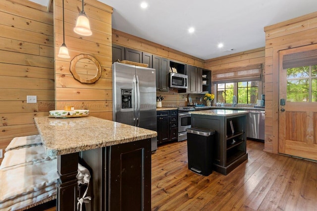 134 Turtle Point Dr, Crane Hill, AL 35053 - kitchen featuring appliances with stainless steel finishes, wood walls, open shelves, wood-type flooring, and a breakfast bar area