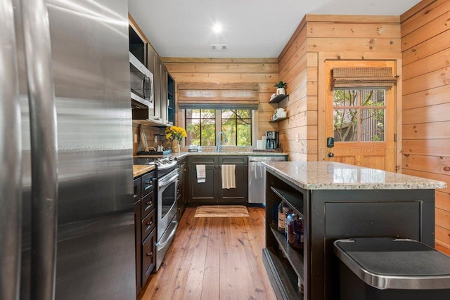134 Turtle Point Dr, Crane Hill, AL 35053 - kitchen with appliances with stainless steel finishes, open shelves, wooden walls, light stone countertops, and wood-type flooring