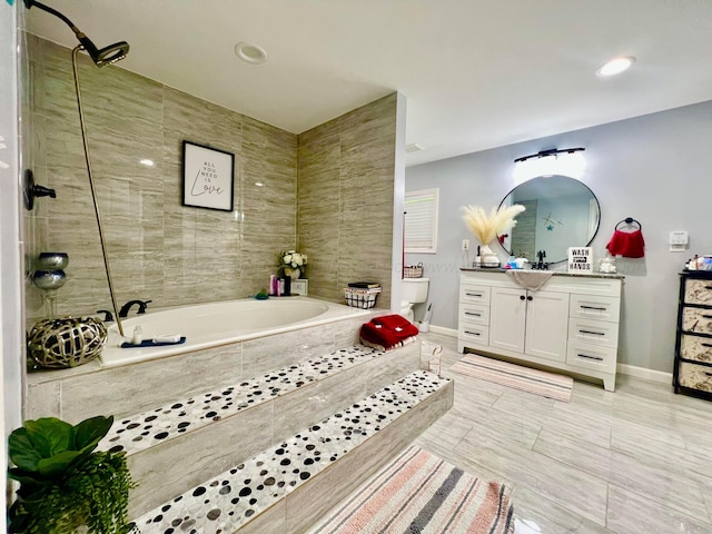 bathroom with baseboards, a relaxing tiled tub, a tile shower, tile patterned flooring, and vanity