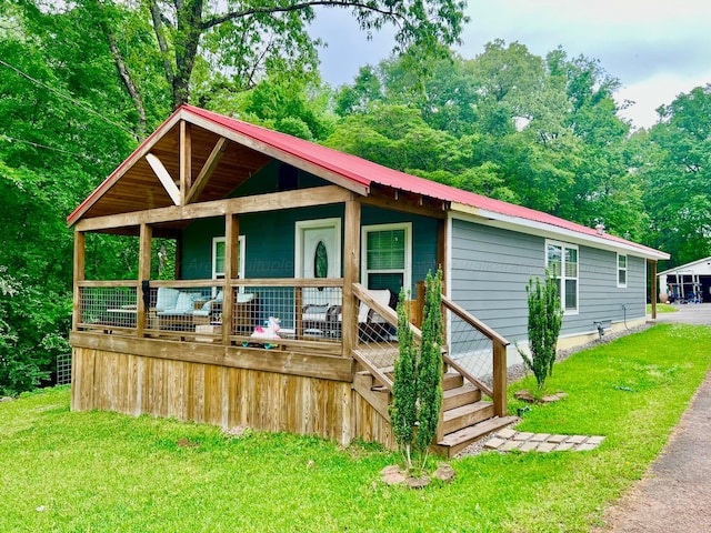 view of front facade featuring metal roof and a front yard