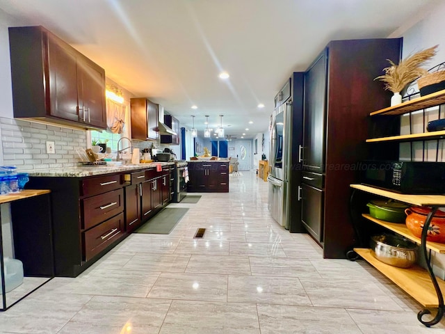 kitchen featuring a sink, stainless steel appliances, tasteful backsplash, marble finish floor, and light stone countertops