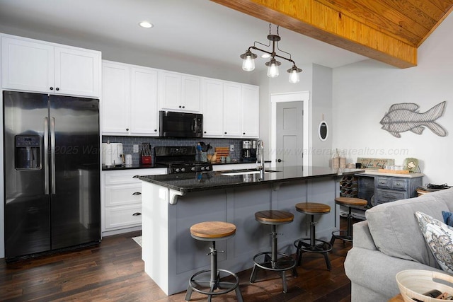 1433 Sipsey Pines Rd, Arley, AL 35540 - kitchen with black appliances, a sink, dark wood-style floors, tasteful backsplash, and a breakfast bar area