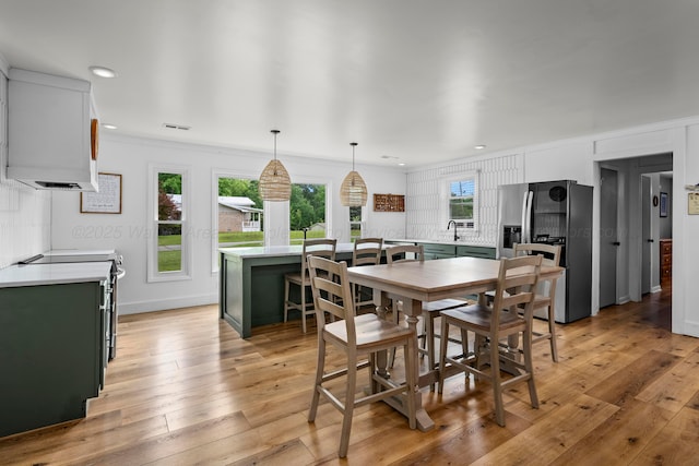 dining room featuring light wood-type flooring, recessed lighting, and ornamental molding