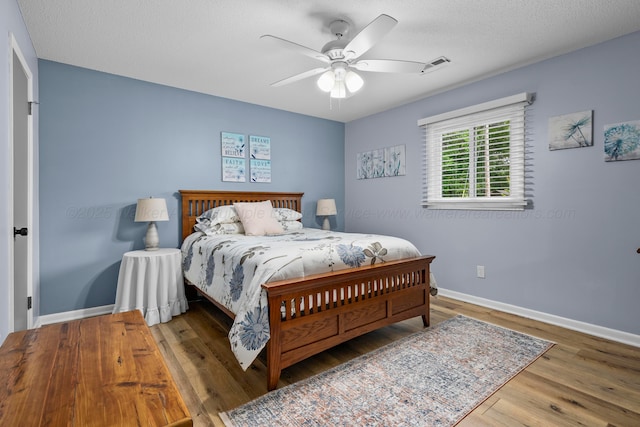bedroom featuring wood finished floors, baseboards, and a ceiling fan