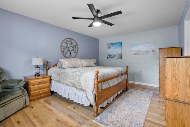 bedroom with light wood-type flooring, baseboards, and a ceiling fan