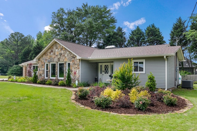 view of front of home with cooling unit, a front lawn, stone siding, and roof with shingles