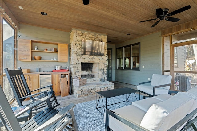 view of patio / terrace featuring an outdoor living space with a fireplace, a wooden deck, and ceiling fan