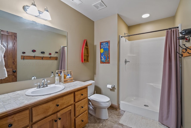 bathroom with tile patterned flooring, a shower with curtain, vanity, and toilet