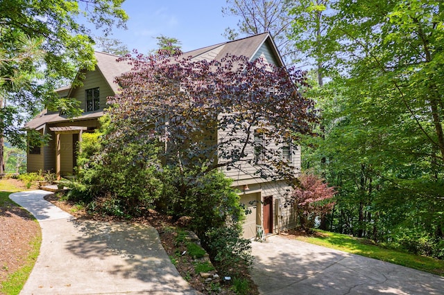 view of property hidden behind natural elements with a garage