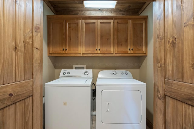 laundry room with washer and clothes dryer, cabinets, and wooden ceiling