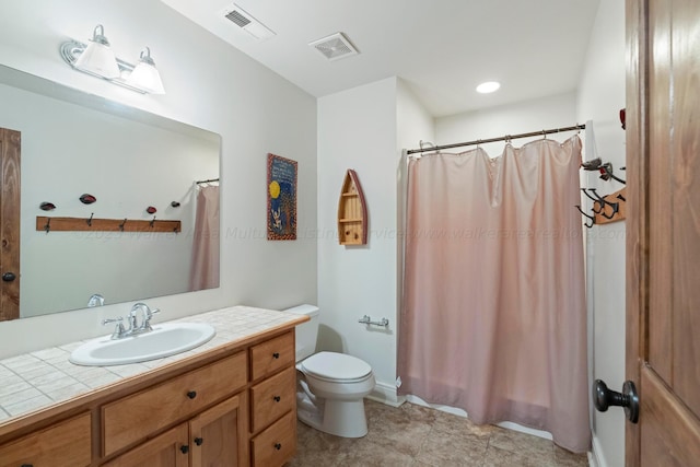 bathroom with tile patterned flooring, vanity, toilet, and walk in shower