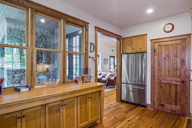 kitchen with wooden counters, high quality fridge, and light hardwood / wood-style flooring