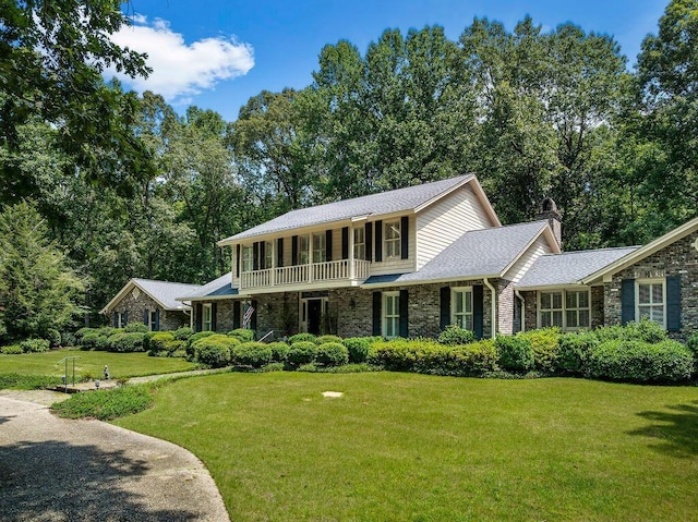 601 Glen Oaks Cir, Jasper, AL 35504 - view of front facade with a front yard, a chimney, a balcony, stone siding, and brick siding
