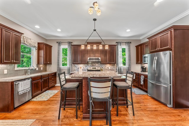136 Grand Magnolia, Jasper, AL 35504 - kitchen featuring appliances with stainless steel finishes, a sink, under cabinet range hood, healthy amount of natural light, and crown molding