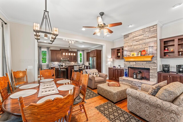 136 Grand Magnolia, Jasper, AL 35504 - dining space with crown molding, ceiling fan, light wood finished floors, a stone fireplace, and recessed lighting