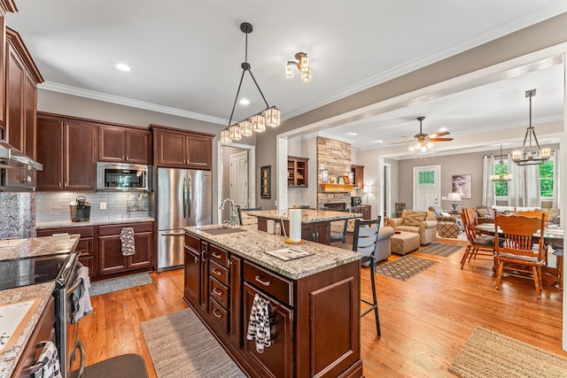 136 Grand Magnolia, Jasper, AL 35504 - kitchen featuring appliances with stainless steel finishes, a breakfast bar area, ceiling fan, a center island with sink, and a sink