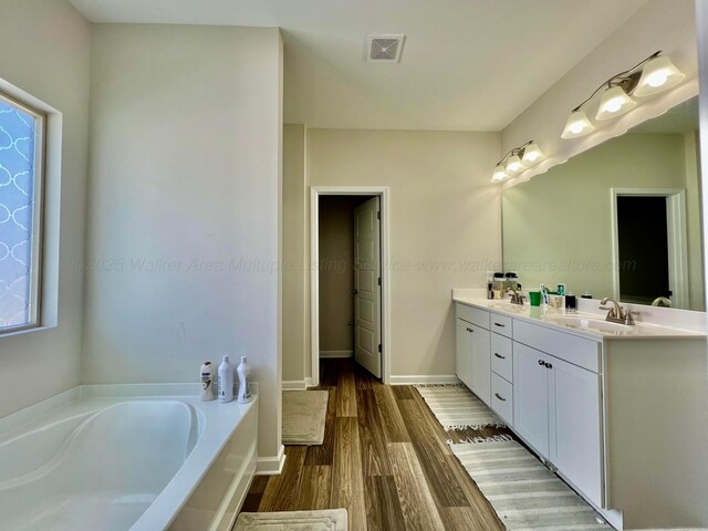 405 Meadow Way, Jasper, AL 35504 - bathroom featuring double vanity, a bath, wood finished floors, and healthy amount of natural light