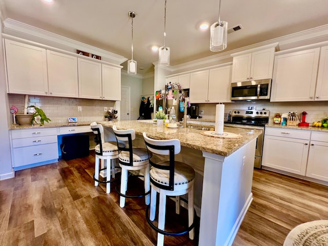 405 Meadow Way, Jasper, AL 35504 - kitchen with appliances with stainless steel finishes, backsplash, ornamental molding, white cabinetry, and a center island with sink