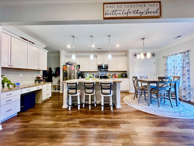 405 Meadow Way, Jasper, AL 35504 - kitchen with stainless steel appliances, white cabinets, ornamental molding, a breakfast bar, and backsplash