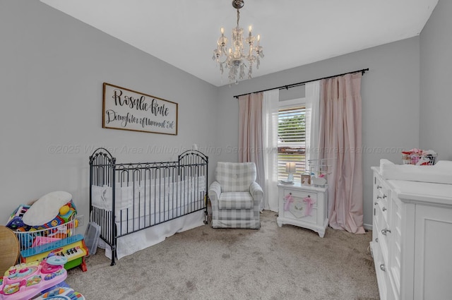 bedroom with a notable chandelier, carpet flooring, and a crib