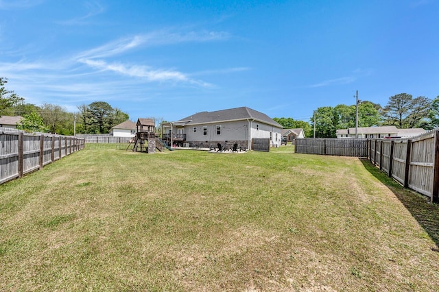 view of yard featuring a fenced backyard and a playground