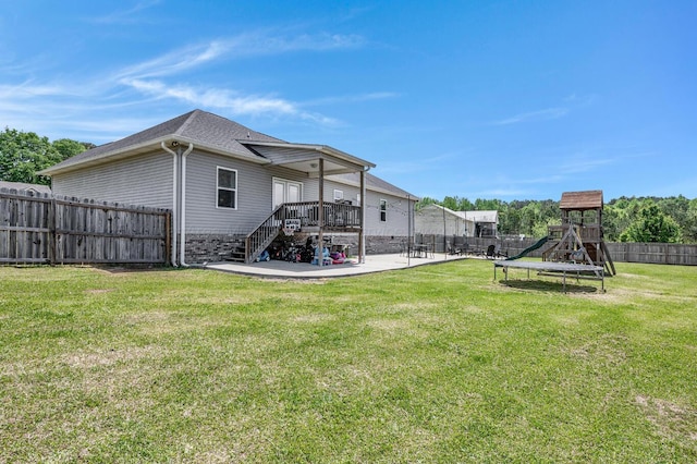 back of property featuring stairs, a playground, a fenced backyard, a patio, and a lawn