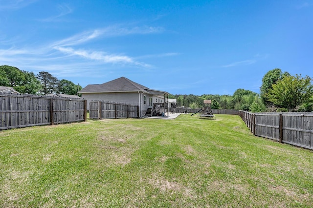 view of yard with a fenced backyard and stairway