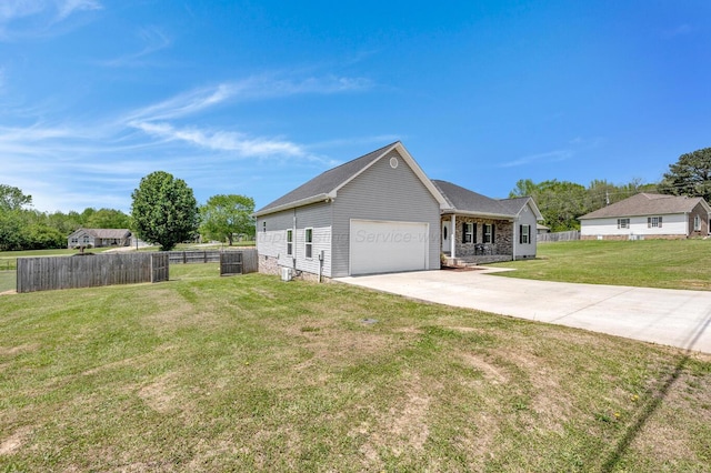 view of side of home with fence, an attached garage, driveway, and a yard