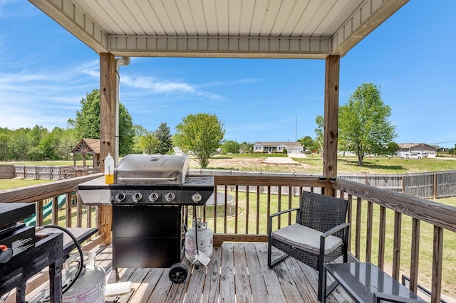 deck featuring grilling area, a fenced backyard, and a lawn