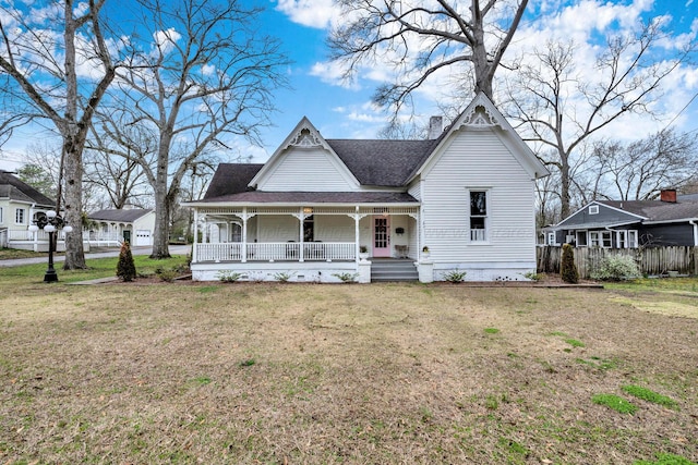 victorian house featuring a porch, roof with shingles, and a front lawn