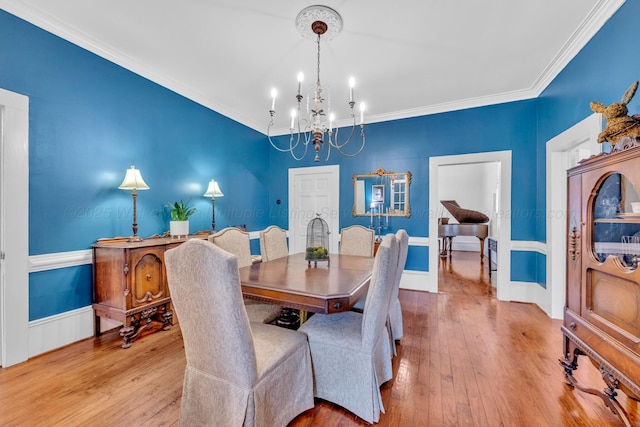 dining room featuring hardwood / wood-style floors, an inviting chandelier, and crown molding