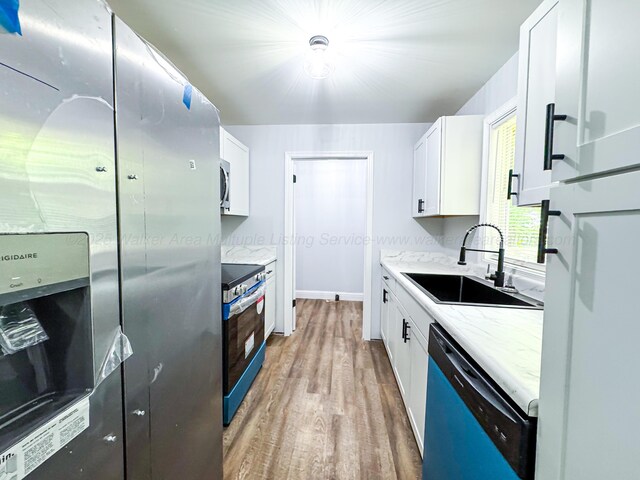 2214 SW 8 Th Ave, Fayette, AL 35555 - kitchen featuring appliances with stainless steel finishes, light wood finished floors, white cabinetry, and light stone countertops