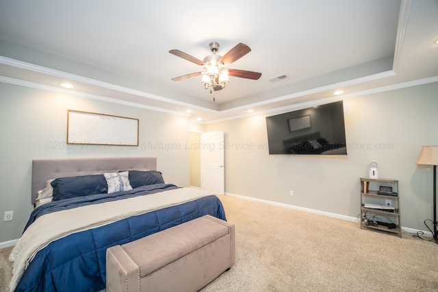 carpeted bedroom featuring baseboards, visible vents, ornamental molding, and a raised ceiling