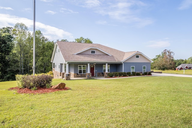 view of front of property featuring a front lawn, stone siding, a porch, and roof with shingles