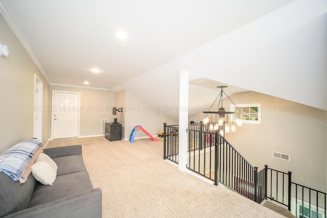 living area featuring crown molding, lofted ceiling, carpet, a chandelier, and visible vents