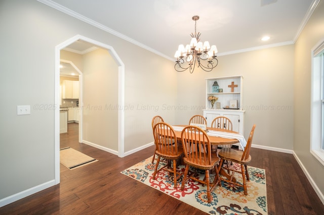 dining room with dark wood-type flooring, crown molding, and a notable chandelier