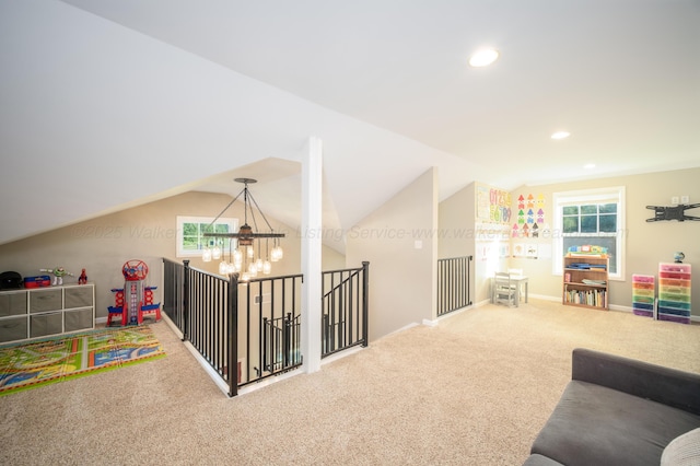 rec room with a wealth of natural light, a notable chandelier, carpet floors, and vaulted ceiling