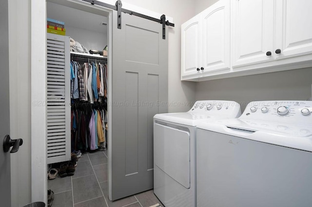 washroom with washer and clothes dryer, cabinets, dark tile patterned floors, and a barn door