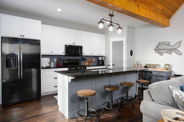 kitchen featuring stove, sink, stainless steel fridge, and a breakfast bar