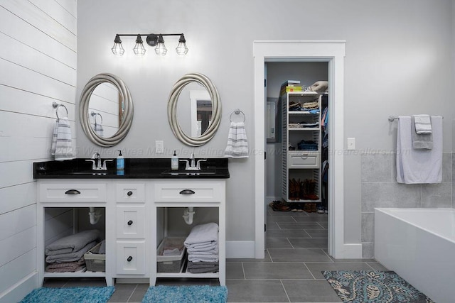 bathroom with tile patterned flooring, vanity, and a bathing tub