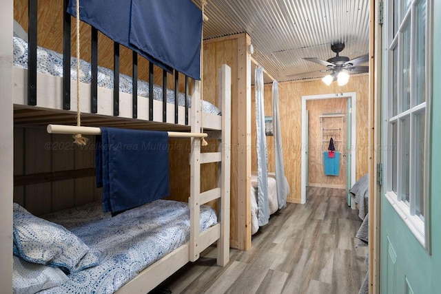 bedroom featuring wood-type flooring, wooden ceiling, and wooden walls