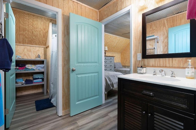 bathroom with vanity, hardwood / wood-style floors, and wood walls