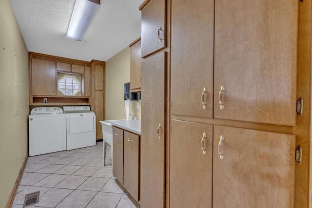 5305 Split Rail Dr, Jasper, AL 35503 - laundry area featuring cabinet space, washer and dryer, light tile patterned floors, and a textured ceiling