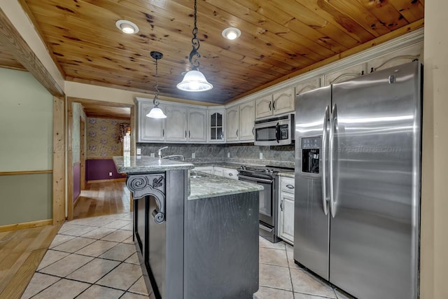 5305 Split Rail Dr, Jasper, AL 35503 - kitchen with appliances with stainless steel finishes, wood ceiling, glass insert cabinets, pendant lighting, and light stone countertops