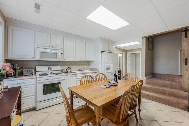 436 Ducktail Rd, Houston, AL 35572 - kitchen with white appliances, light tile patterned floors, light countertops, a drop ceiling, and white cabinets